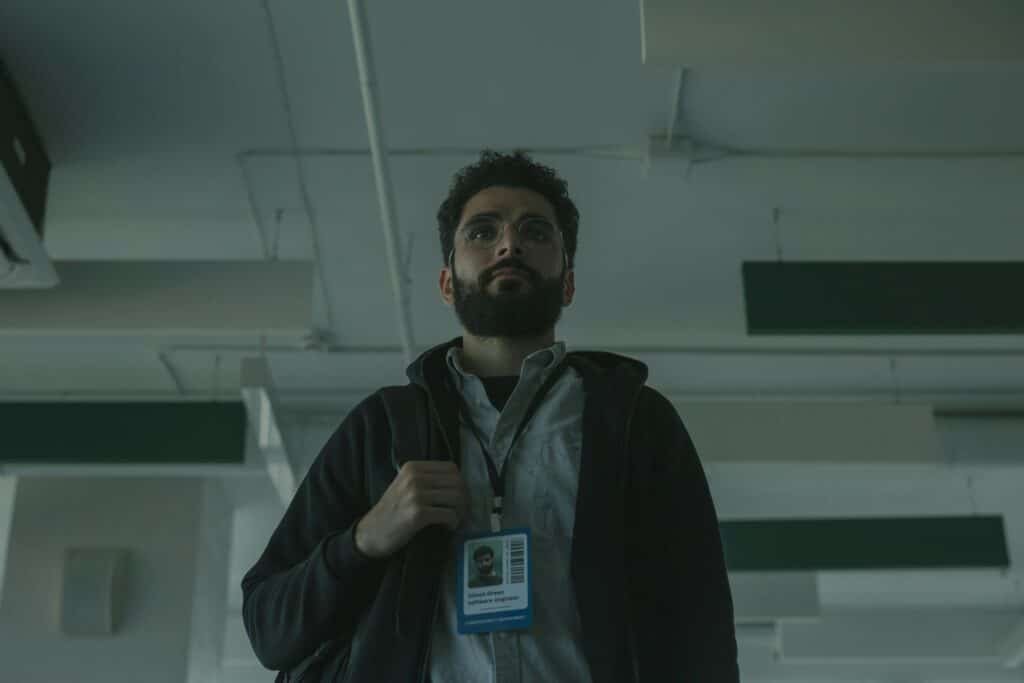 Portrait of a bearded man with ID indoors, signifying technology role.