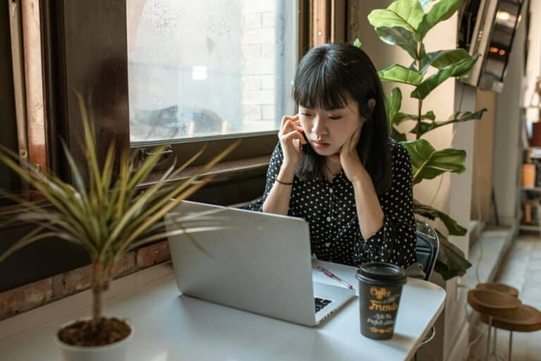 Woman on a phone call while looking at a laptop – preparing for a tech recruiter interview